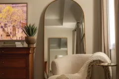 Elegant Bedroom with Gold-Framed Mirror and Accent Chair