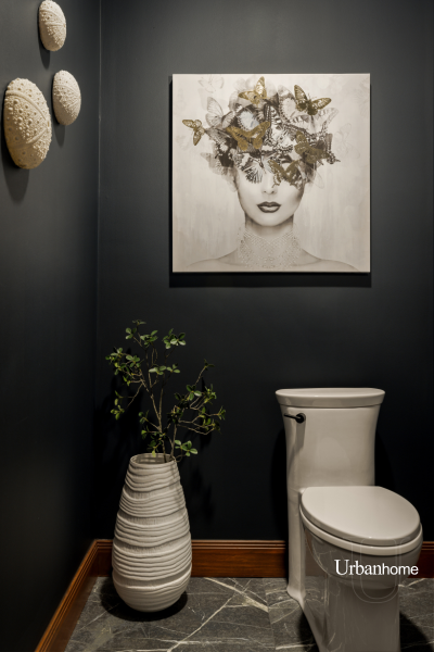 Artistic powder room with dark walls and a striking black and white portrait above the toilet.