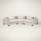 Curved modular sectional sofa in a soft, neutral fabric with tailored lines and multiple accent cushions.