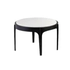 Pair of round nesting side tables with sculpted black metal frames and white marble tops, styled in front of a sectional in a bright living room.