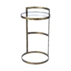 Small round accent table with an antique brass-finished frame and a clear glass top, styled beside a modern armchair in a neutral living space.