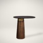 Oval black stone-topped side table with a flared wood base and brass detailing, styled next to a modern sofa in a sunlit living room.