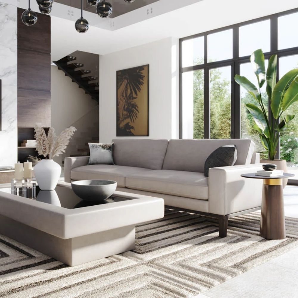 Oval black stone-topped side table with a flared wood base and brass detailing, styled next to a modern sofa in a sunlit living room.
