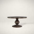 60-inch round pedestal dining table in dark-stained solid wood with a sculptural, turned base and smooth beveled edge.
