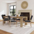 A rustic modern rectangular dining table made of natural wood with thick, block-style legs and a clean-lined silhouette.