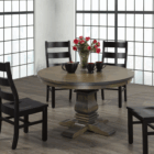 Traditional round dining table in a rich wood tone with a sculpted pedestal base and cross-shaped feet.