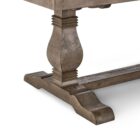Rustic rectangular dining table with a thick wooden top and two carved pedestal legs connected by a stretcher base.