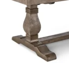 Rustic rectangular dining table with a thick wooden top and two carved pedestal legs connected by a stretcher base.