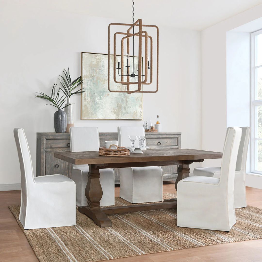 Rustic rectangular dining table with a thick wooden top and two carved pedestal legs connected by a stretcher base.