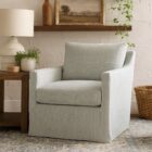 Soft blue upholstered swivel glider chair with tailored arms and plush back cushion.