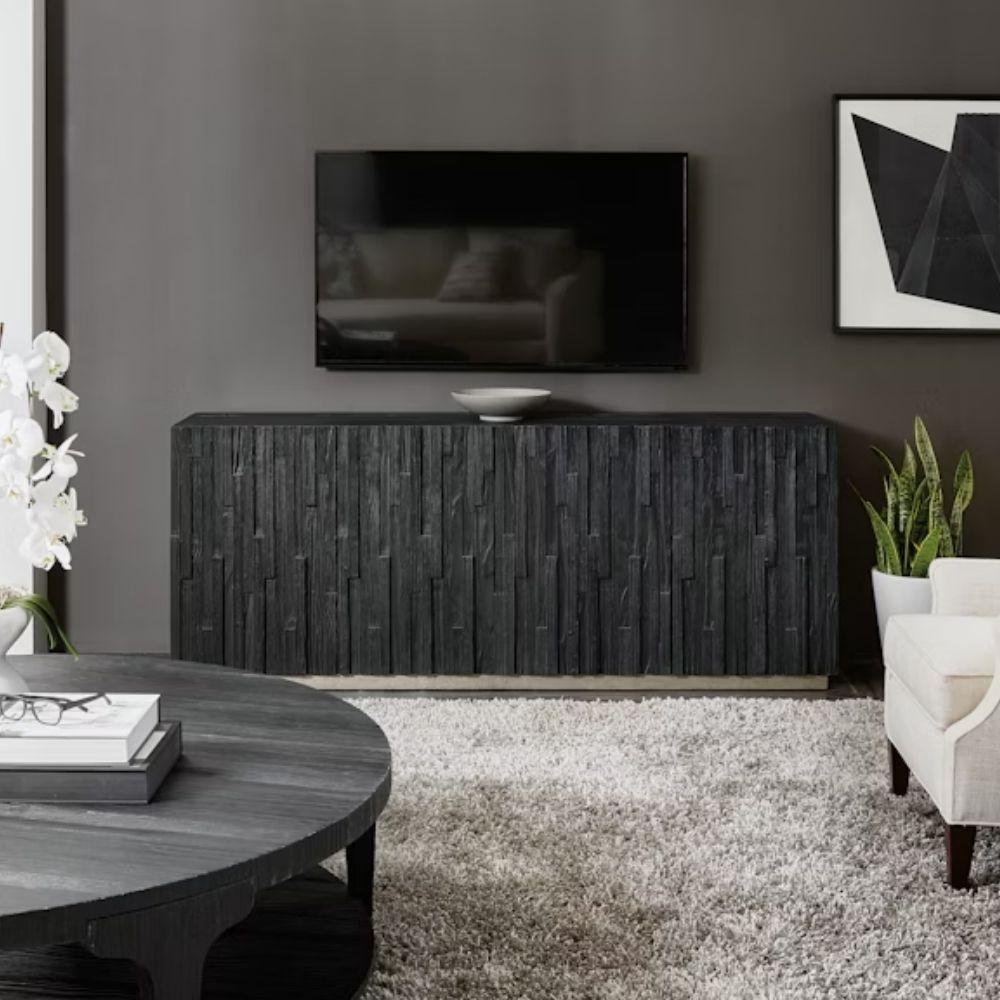 Charred black entertainment console with vertically stacked wood texture and subtle metallic base, inspired by the Shou Sugi Ban technique.