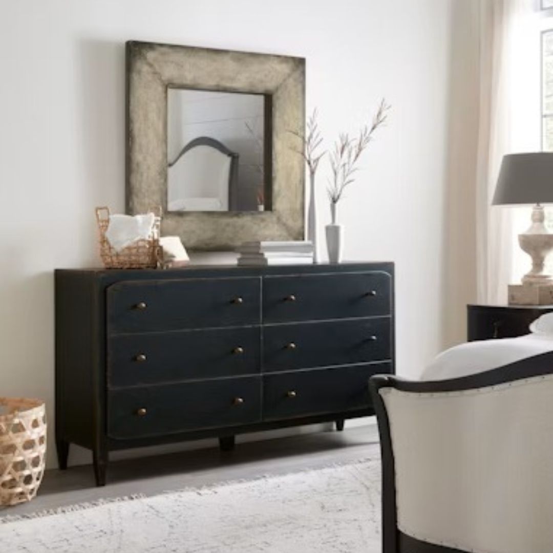 Black six-drawer dresser with brass knobs and lightly distressed finish.