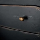 Black distressed wood two-drawer nightstand with tapered legs and rounded drawer fronts.
