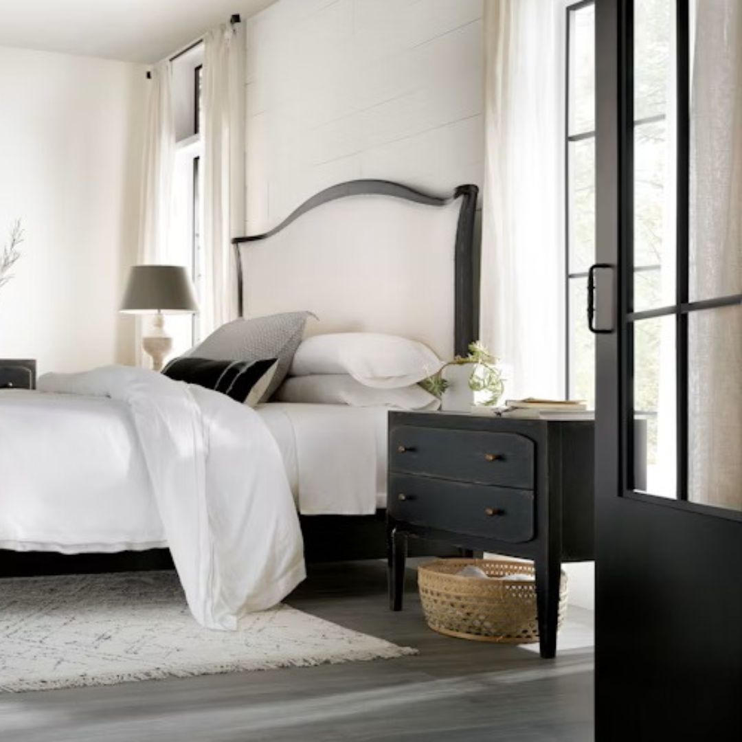 Black distressed wood two-drawer nightstand with tapered legs and rounded drawer fronts.