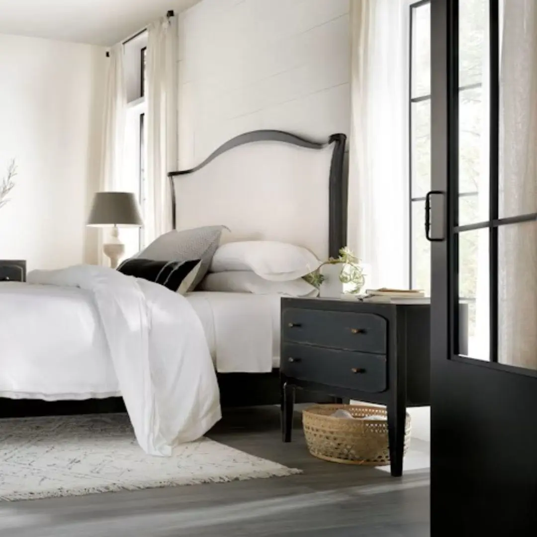Black distressed wood two-drawer nightstand with tapered legs and rounded drawer fronts.
