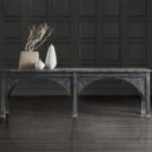 Long black console table with cathedral-inspired arch detailing and a distressed wood finish.