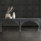 Long black console table with cathedral-inspired arch detailing and a distressed wood finish.