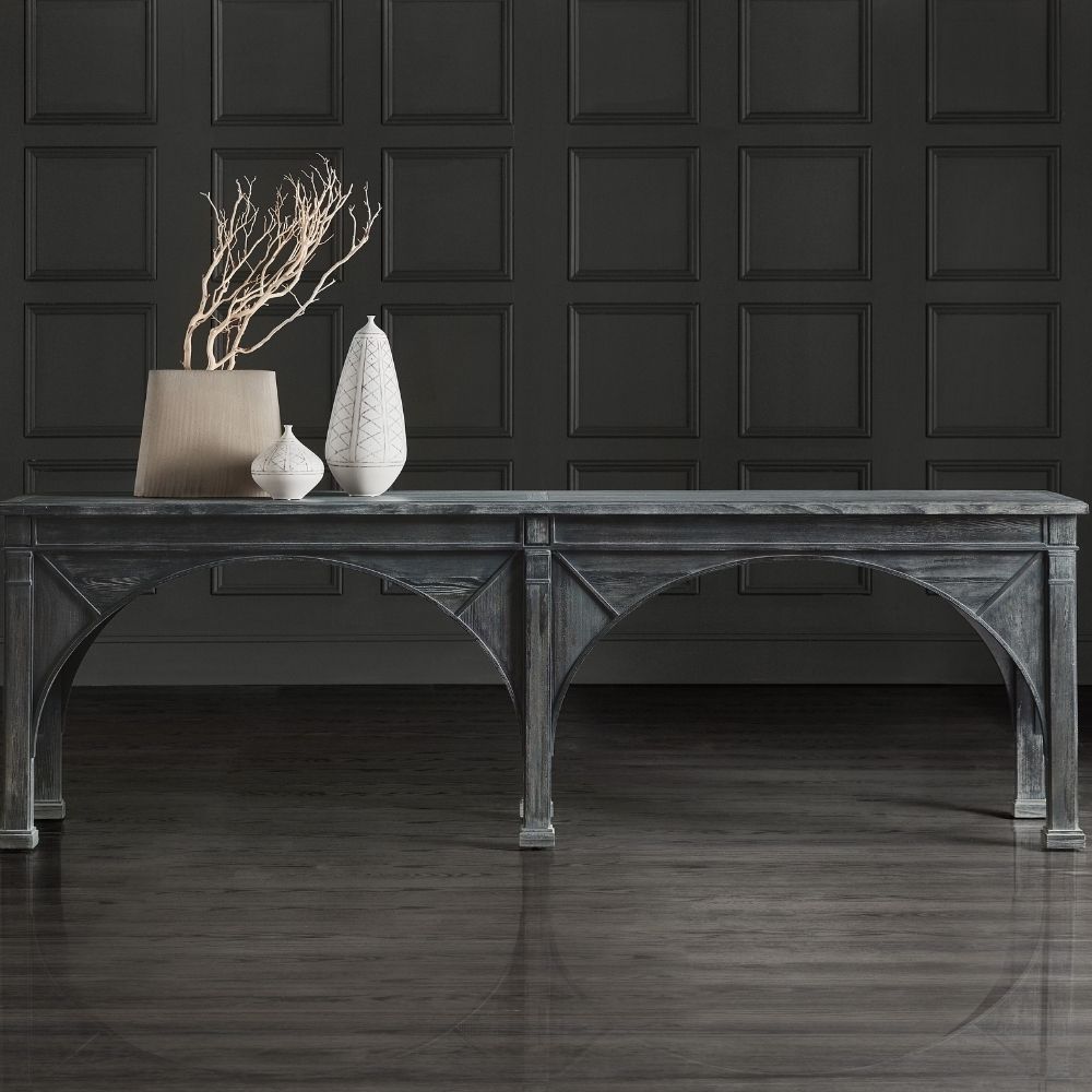 Long black console table with cathedral-inspired arch detailing and a distressed wood finish.