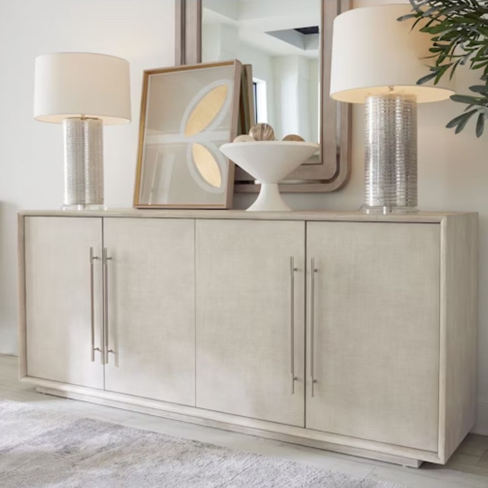 Light wood entertainment console with four panel doors, oversized vertical pulls, and a sleek, minimalist silhouette.