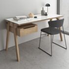 Minimalist birch wood desk with cream top and integrated drawer unit on the left side.