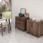 Three-drawer walnut wood cabinet with minimalist silhouette and integrated pulls.