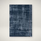Abstract navy and grey area rug with distressed texture, overhead view.