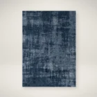 Abstract navy and grey area rug with distressed texture, overhead view.