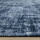Abstract navy and grey area rug with distressed texture, overhead view.