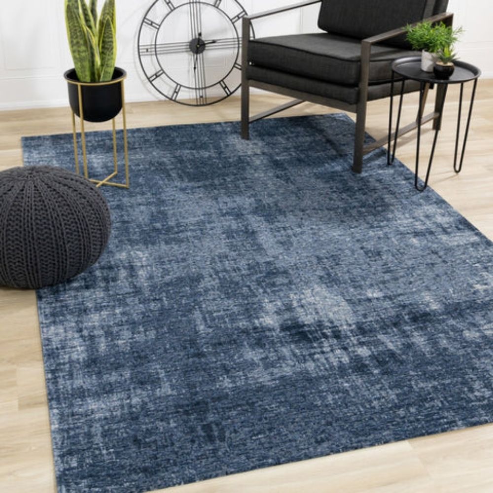 Abstract navy and grey area rug with distressed texture, overhead view.