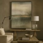 Abstract wall art featuring a misty, ethereal landscape in soft shades of beige, grey, and green with warm golden undertones.