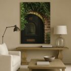 Photograph of a rustic black arched door with the number 17, framed by ivy and aged brick.