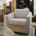 Modern white club chair with plush cushions, curved arms, and dark wooden legs.