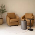 Modern club chair with plush cushions, curved arms, and dark wooden legs.