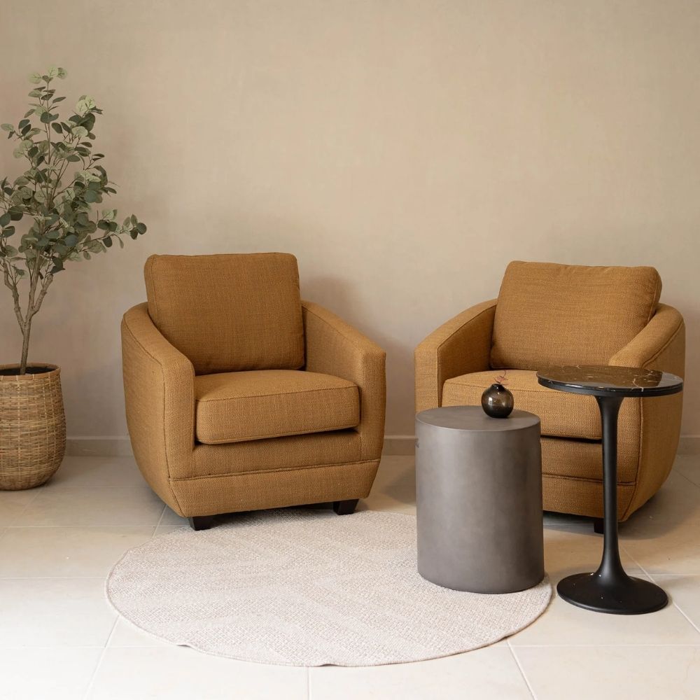 Modern club chair with plush cushions, curved arms, and dark wooden legs.