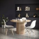 Round natural wood dining table with a fluted cylindrical pedestal base and smooth tabletop.