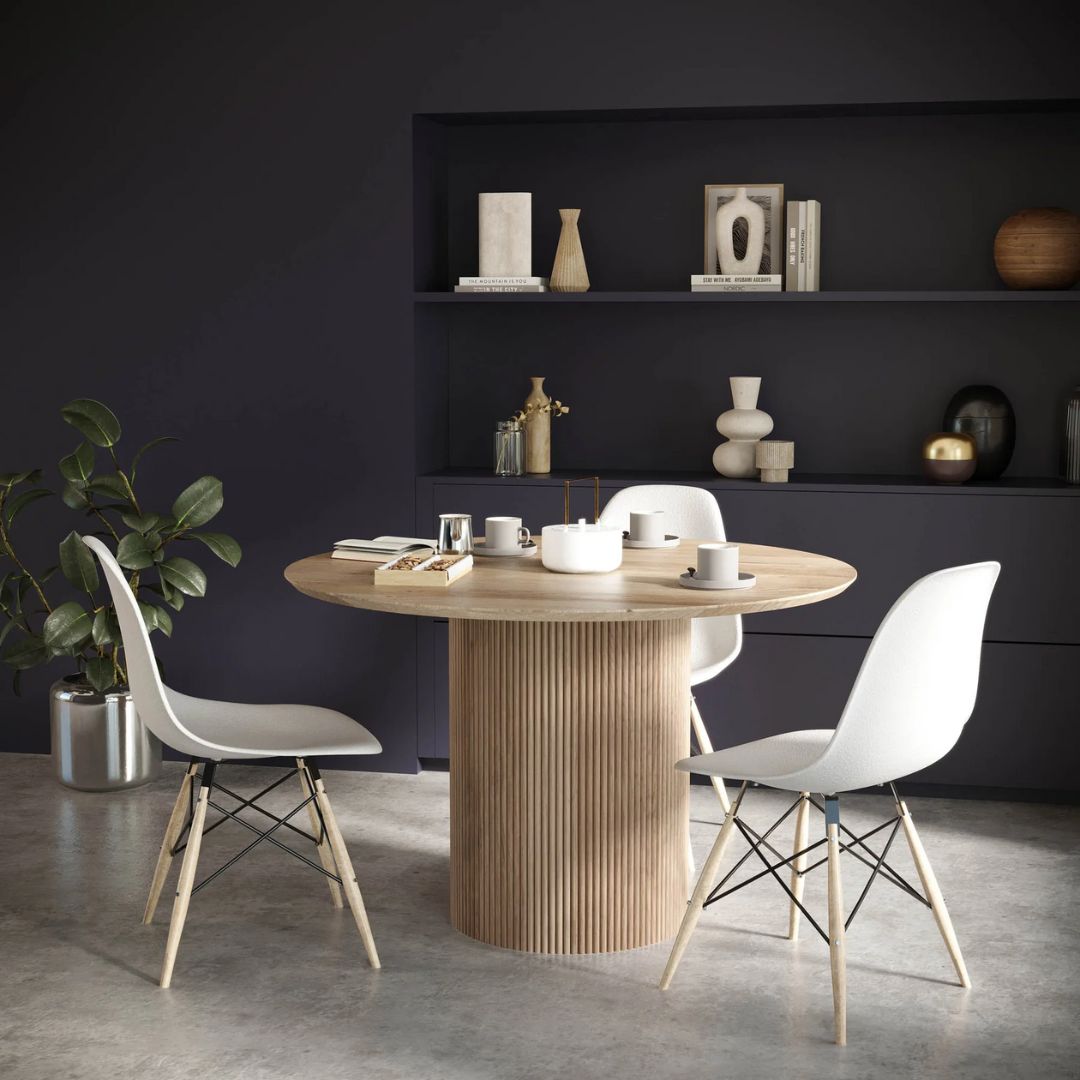 Round natural wood dining table with a fluted cylindrical pedestal base and smooth tabletop.