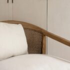 Contemporary accent chair with light boucle cushions and natural wood frame featuring open cane sides.