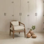 Contemporary accent chair with light boucle cushions and natural wood frame featuring open cane sides.