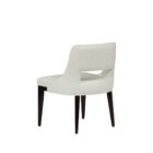Barilla Dining Chair featuring an off-white upholstered seat with a sleek cut-out backrest and dark wooden legs.
