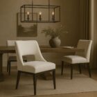 Barilla Dining Chair featuring an off-white upholstered seat with a sleek cut-out backrest and dark wooden legs.