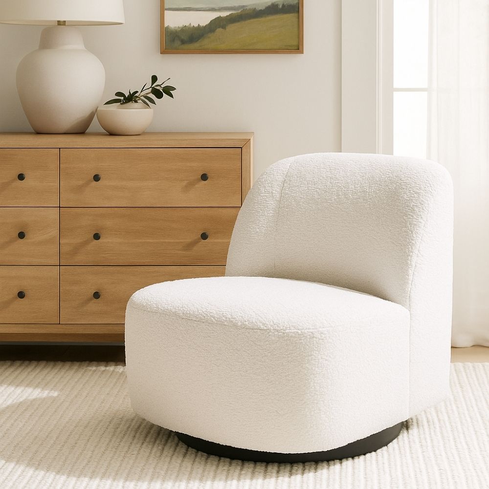 Minimalist white boucle swivel chair with soft curves and black base.