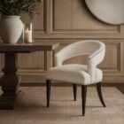 Charles Dining Chair, upholstered in a soft white velvet fabric with a curved backrest, nailhead trim, and tapered dark wood legs.