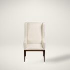 A high-back, upholstered dining chair with wingback arms, straight profile, and a dark wood leg frame.