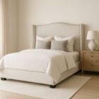 Elegant beige upholstered Layla Bed with curved headboard and minimalist bedroom styling.