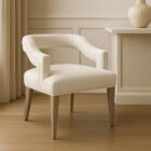 Elegant modern dining armchair with sculpted backrest and plush ivory upholstery, shown in both a lifestyle interior and isolated product view.