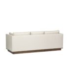 Contemporary cream-colored sofa with structured arms, three back cushions, and a recessed wood base.