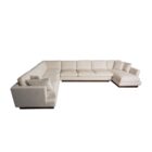Modern beige sectional sofa with deep seating, clean lines, and a recessed dark wood base.