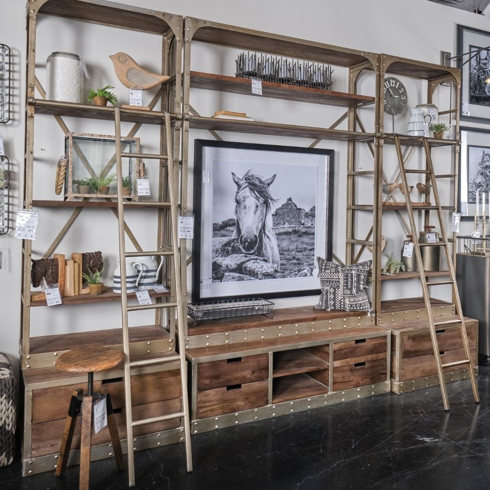 Tall industrial-style shelving unit with metal frame, wood shelves, integrated bottom drawers, and a leaning metal ladder.