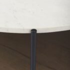 Round two-tier coffee table with white marble top, dark wood lower shelf, and black metal frame.
