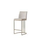 A modern upholstered counter stool with a curved brass-finished metal base and light neutral fabric seat and back.